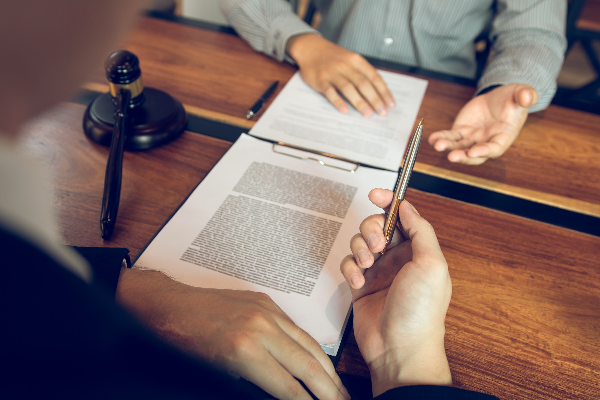 Legal advisor is explaining the offense under the law in the book at office.